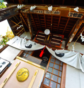 Traditional Japanese shrine interior with wooden beams, lanterns, and serene atmosphere in Tokyo.