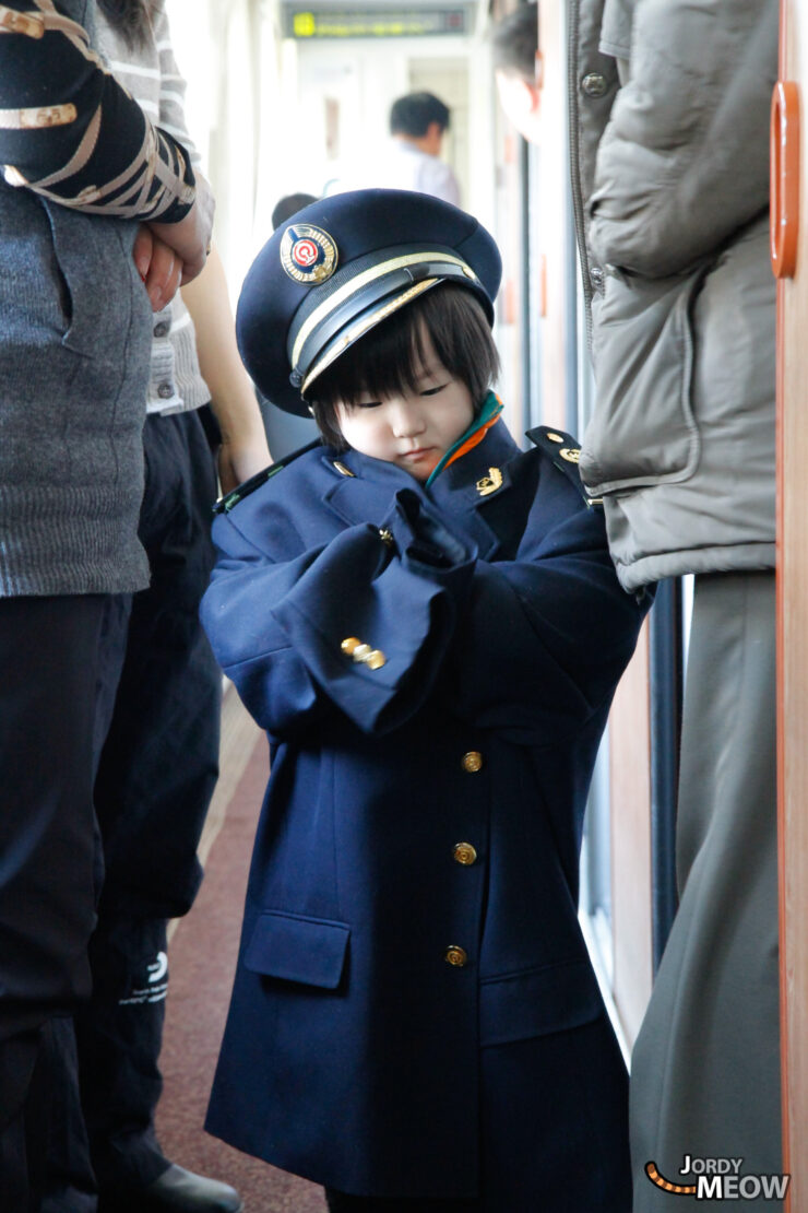 Exploring North Korean culture: Child in traditional uniform on public transit.