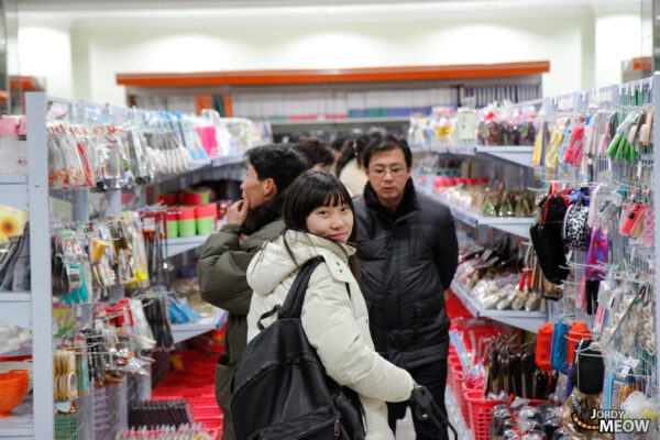 Inside a lively marketplace in Pyongyang, North Korea - bustling with shoppers and vendors.