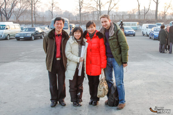 Group of people smiling in North Korean urban setting, exploring and enjoying the surroundings.