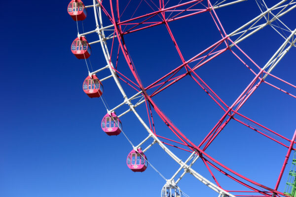 Whimsical red Ferris wheel in lush Hitachi Seaside Park, Japan.