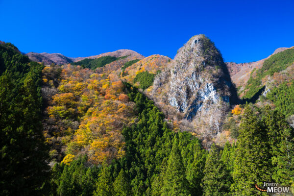 Majestic Inamura Rock in Japan: Autumn beauty amidst vibrant foliage and clear skies.