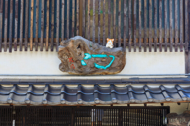 Cozy cats on weathered fence, historic Japanese street.