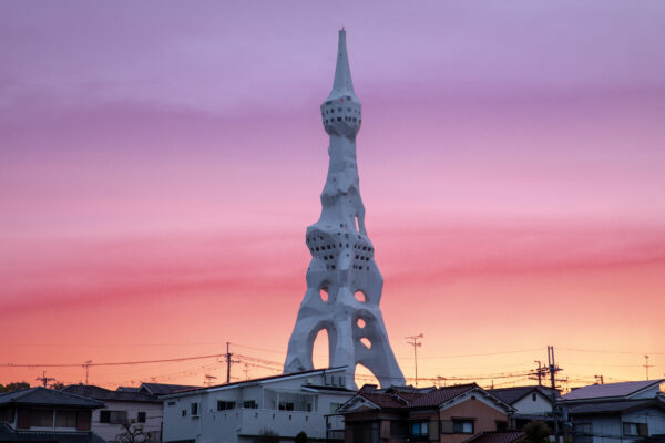 Imposing war memorial tower against sunset skyline.
