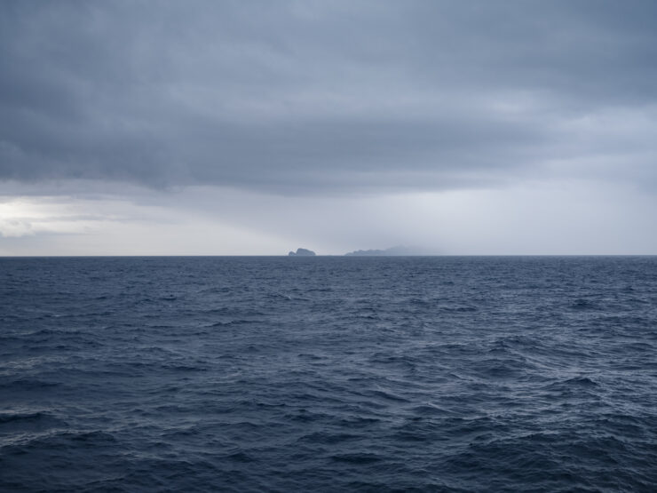 Tranquil navy waves, gloomy sky horizon